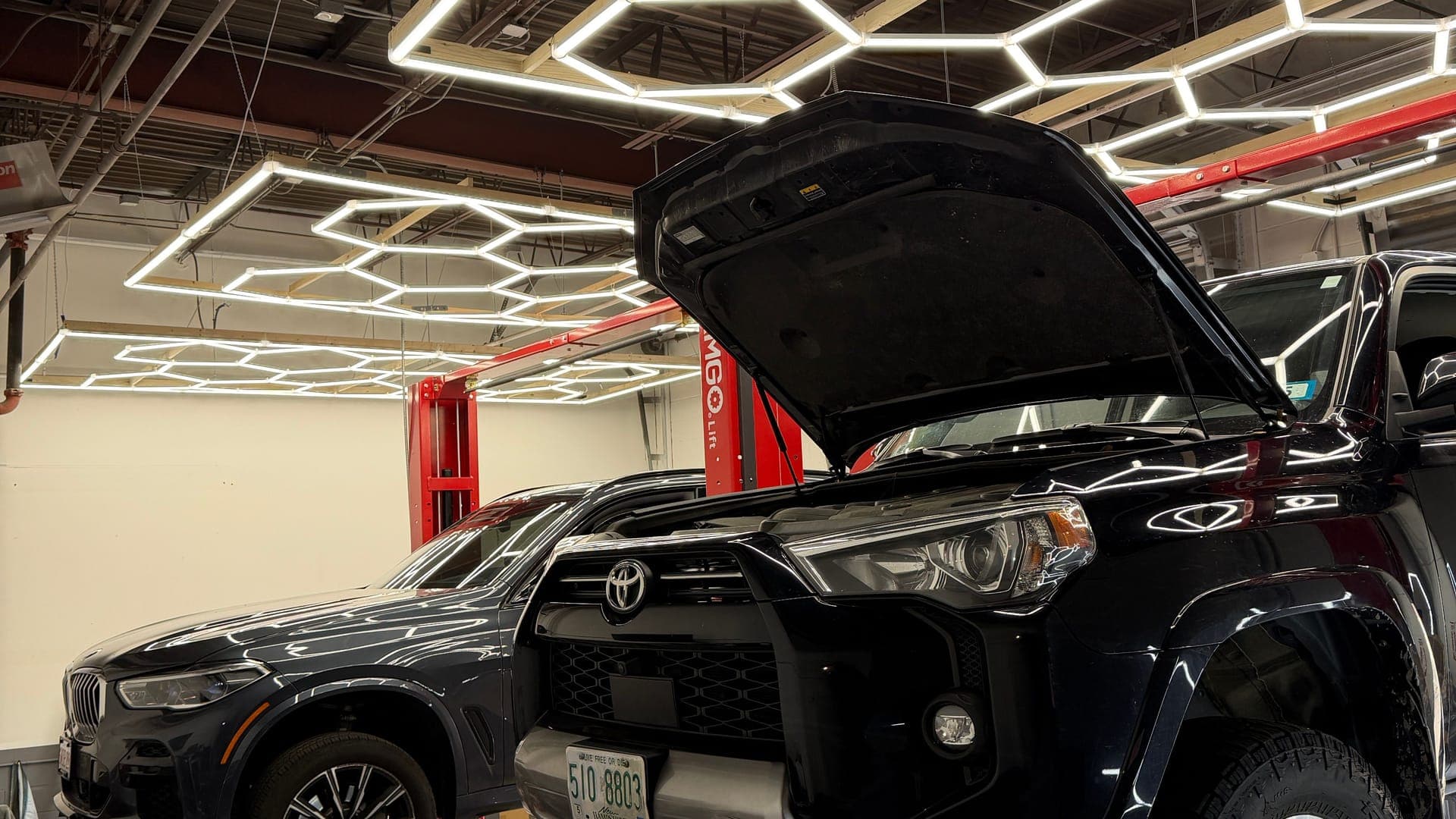 Mechanic performing an oil and fluid service on a vehicle at Pro Tech Auto in Manchester, NH.