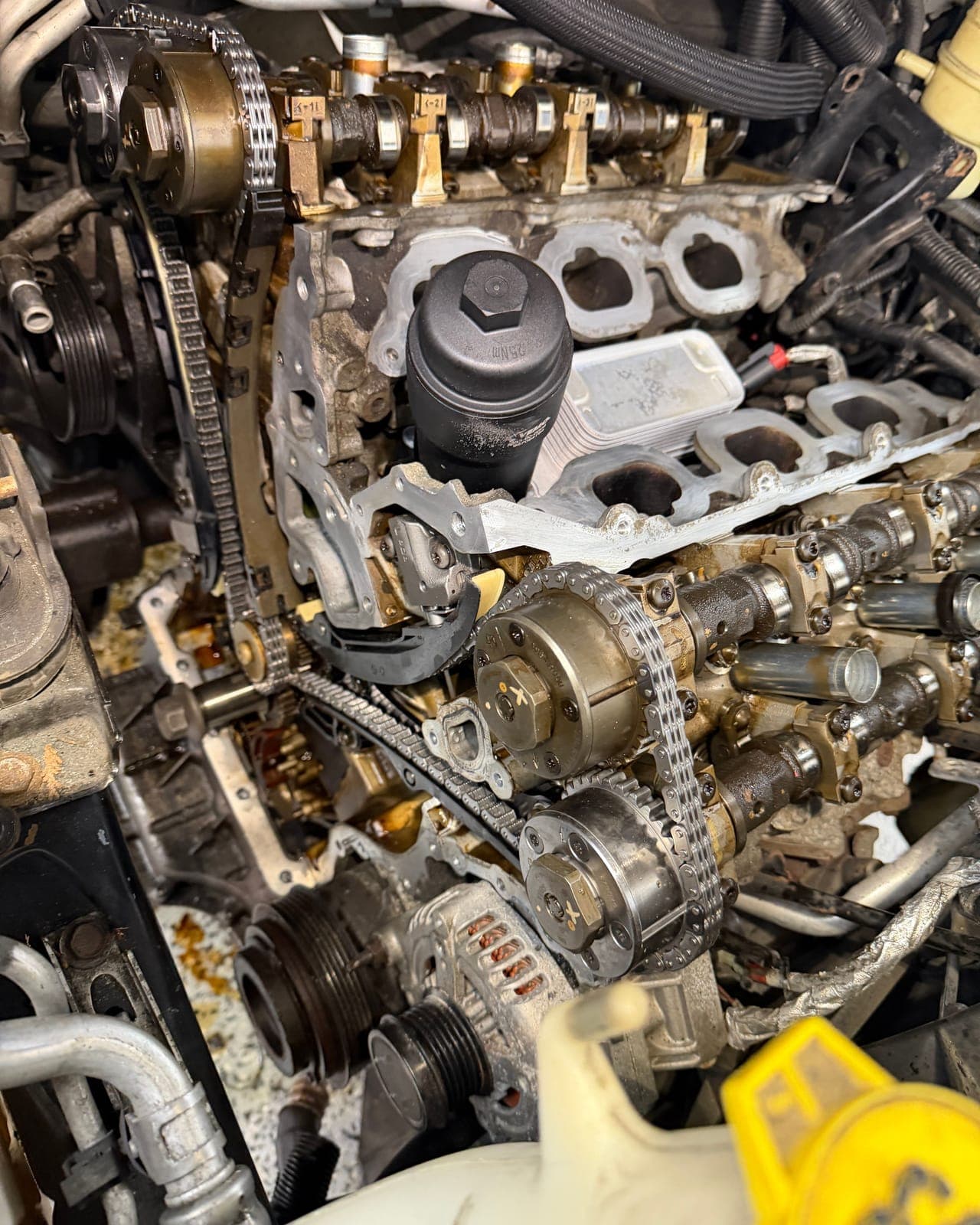 Audi engine bay with timing chain assembly exposed during service.
